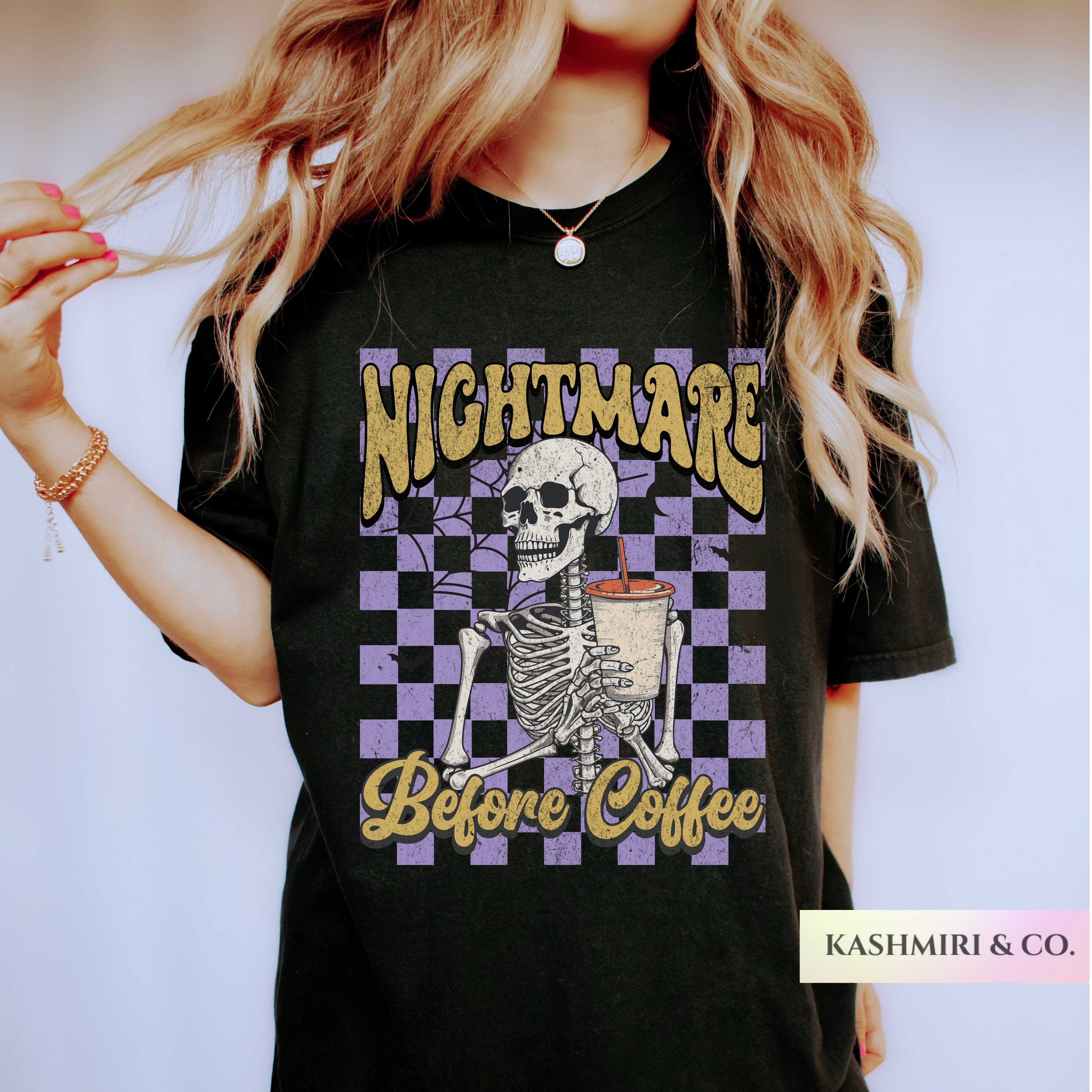A woman wearing a black graphic t-shirt with a purple and gold checkerboard design featuring a skeleton holding a coffee cup and the text 'NIGHTMARE Before Coffee'.