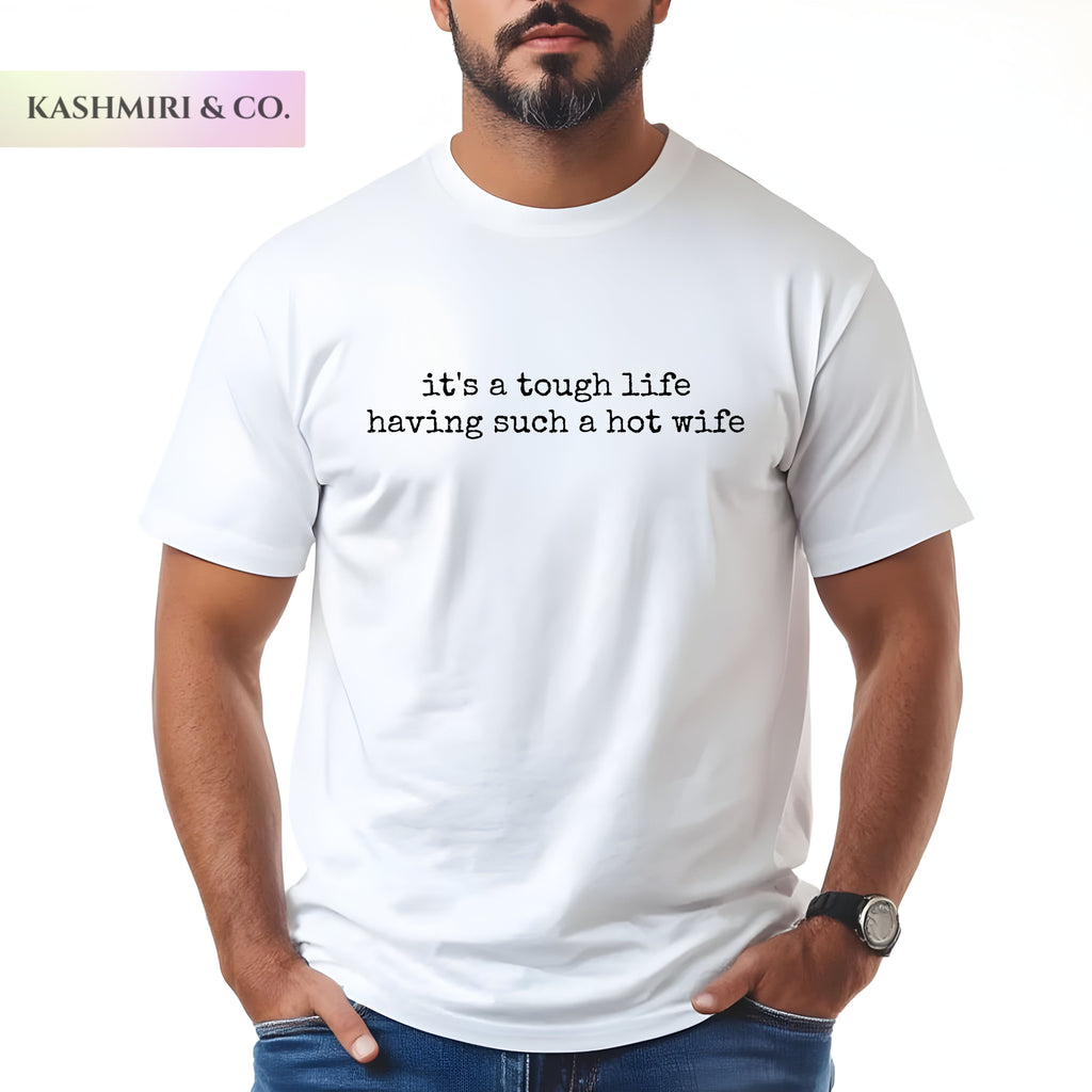 A man wearing a white t-shirt with white printed text that reads 'it's a tough life having such a hot wife'. The brand logo 'KASHMIRI & CO.
