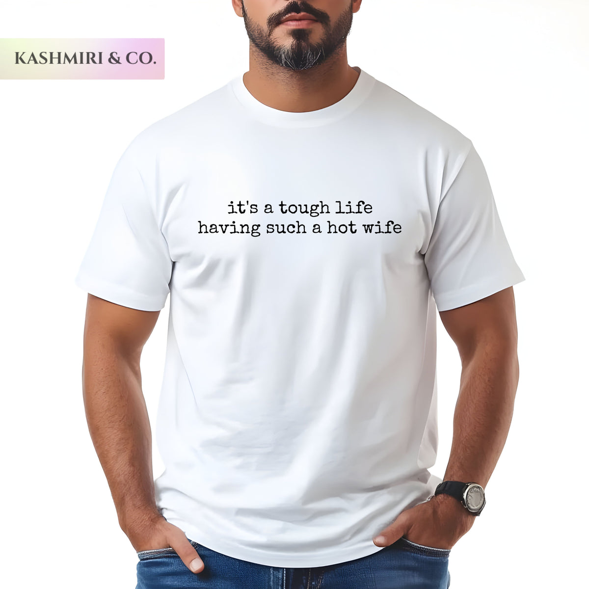 A man wearing a white t-shirt with white printed text that reads 'it's a tough life having such a hot wife'. The brand logo 'KASHMIRI & CO.